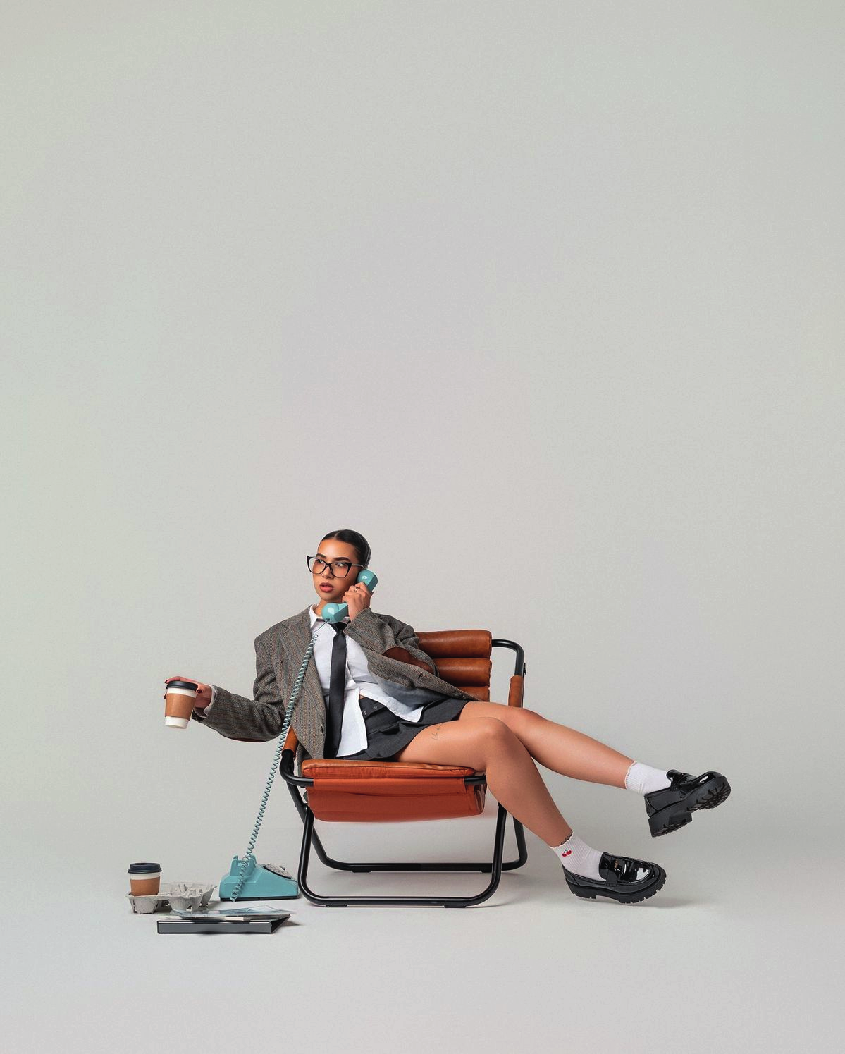 Referencia editorial de una persona con traje en una silla de color óxido